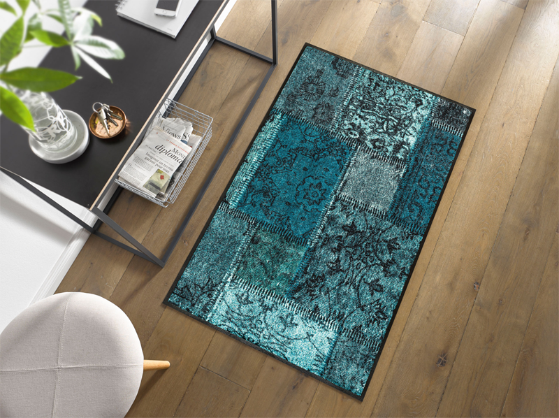 Fußmatte mit türkisen Farbflächen im Eingangsbereich